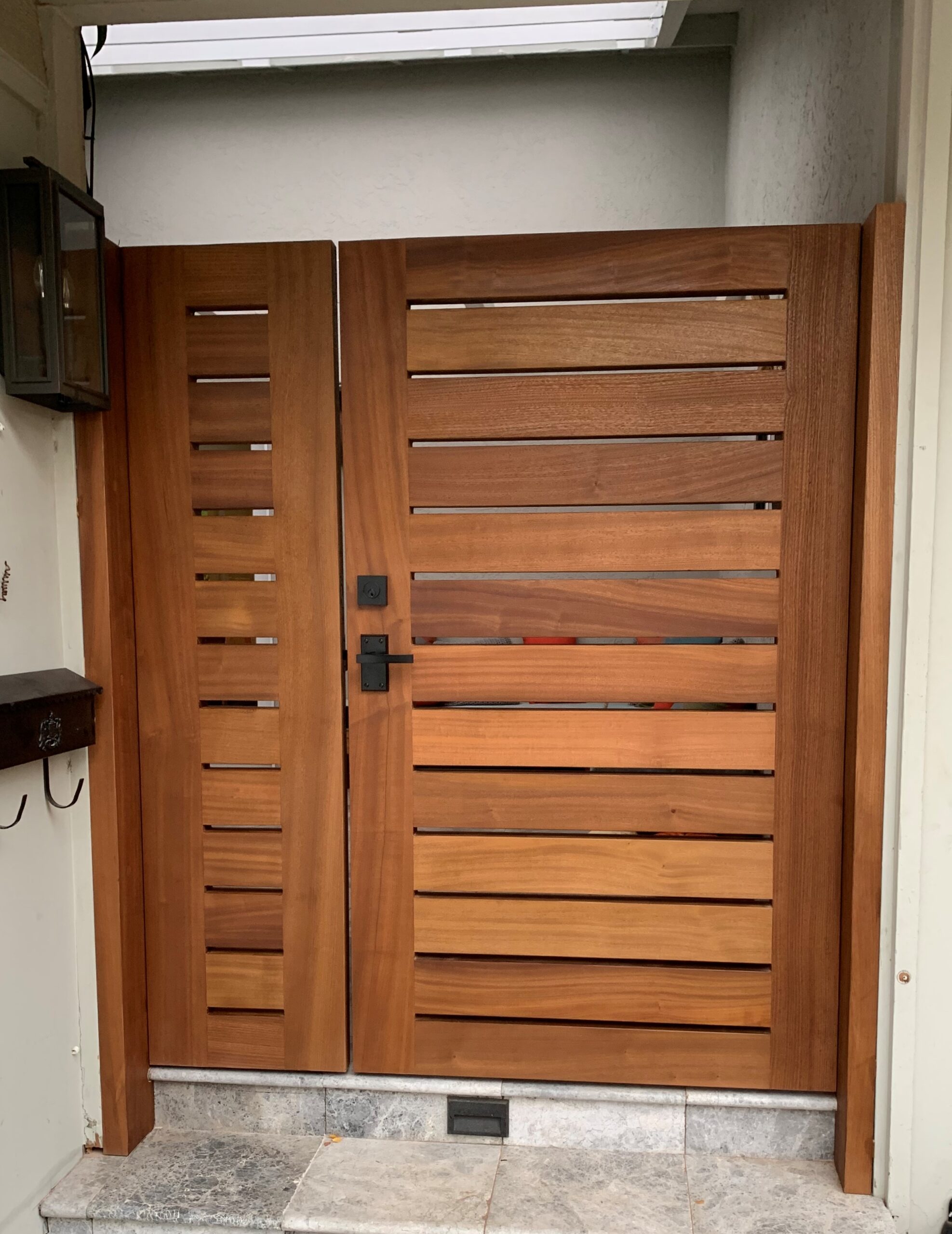 Outside view of sapele courtyard gate with 360 Yardware Nero Contemporary Lever Gate Latch